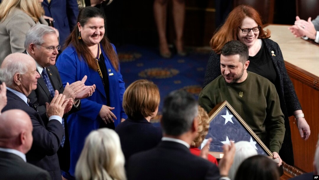 Presiden Ukraina Volodymyr Zelenskyy memegang bendera Amerika yang dihadiahkan kepadanya oleh Ketua DPR AS Nancy Pelosi, seusai berpidato di hadapan rapat gabungan Kongres di Gedung Capitol, Washington, D.C., 21 Desember 2022.
