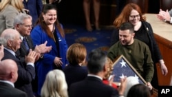 Presiden Ukraina Volodymyr Zelenskyy memegang bendera Amerika yang dihadiahkan kepadanya oleh Ketua DPR AS Nancy Pelosi, seusai berpidato di hadapan rapat gabungan Kongres di Gedung Capitol, Washington, D.C., 21 Desember 2022.