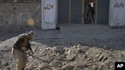 A paramilitary soldier uses a metal detector to survey the site of a bomb attack in Landi Kotal, in northwest Pakistan, December 31, 2011.