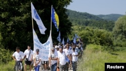 People walk through a forest near the village of Nezuk Wednesday. Several thousand people started an 85-kilometer (53-mile) "March for Peace" from Nezuk to Srebrenica to retrace the route, in reverse, of Bosnian Muslims fleeing Serb forces in 1995. 