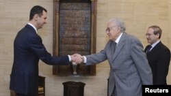 Syria's President Bashar al-Assad (L) shakes hands with U.N.-Arab League peace envoy for Syria Lakhdar Brahimi before a meeting in Damascus October 21, 2012.