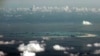 In this Monday, May 11, 2015, file photo, this aerial photo taken through a glass window of a military plane shows China's alleged on-going reclamation of Mischief Reef in the Spratly Islands in the South China Sea.