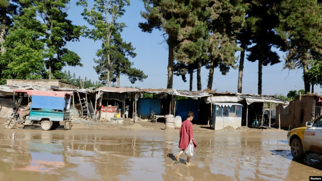 Seorang anak laki-laki berjalan melewati jalan yang terendam banjir di Sheikh Jalal, Provinsi Baghlan, Afghanistan, 12 Mei 2024. (Foto: Sayed Hassib/Reuters/Arsip)