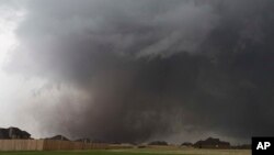 FILE - A tornado moves past homes in Moore, Oklahoma, May 20, 2013. Emergency officials in Oklahoma, Texas and Kansas are bracing for the start of what's historically the most active time of year for tornadoes while also facing wildfire threats because of severe drought conditions.