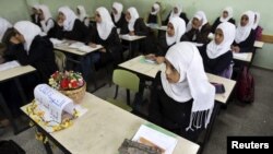 A Palestinian school girl in a Khan Younis school, November 15, 2012, sits next to the chair of a classmate who was killed during an Israeli air strike.