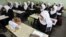 A Palestinian school girl in a Khan Younis school, November 15, 2012, sits next to the chair of a classmate who was killed during an Israeli air strike.