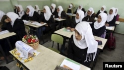 Murid-murid perempuan di Palestina kembali belajar di sekolah di Jalur Gaza, sementara bangku seorang teman kelas mereka Amera Abu Nasser dikosongkan (25/11). Amera tewas dalam serangan udara Israel atas Gaza.