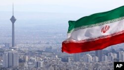 Прапор Ірану на фоні телекомунікаційної вежі у Тегерані 