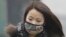A woman wearing a mask walks on a heavy haze day during winter in Beijing January 29, 2013. 
