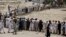 People, who fled the military offensive against Pakistani militants in North Waziristan, line up to receive food supply from the army in Bannu, in Pakistan's Khyber-Pakhtunkhwa province, June 25, 2014.