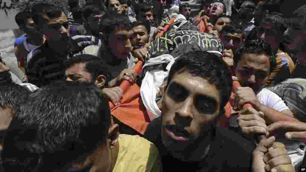 Palestinians carry the body of Islamic Jihad militant Mohammed Sowelim, who was killed in an Israeli air strike, during his funeral in Jabaliya refugee camp, in the northern Gaza Strip, July 12, 2014. 