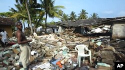 Penyintas tsunami di tengah puing-puing bangunan yang hancur di Pamadura, Kolombo selatan, Srilanka, 30 Desember 2004.