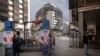 People, keeping a distance, wait in line in front of a shop downtown Madrid, March 16, 2020. 