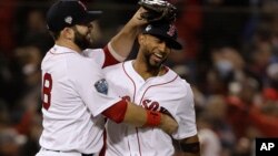 Boston Red Sox's Mitch Moreland, left, celebrates with Eduardo Nunez after Game 1 of the World Series baseball game Tuesday, Oct. 23, 2018, in Boston.