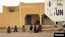 FIEL - Children watch as a Minusma peacekeeping armored vehicle drives past in Kidal, Mali, July 23, 2015. 