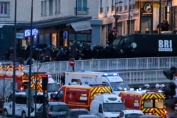 FILE - Police officers storm the kosher market where a gunman held several hostages in Paris, France, Jan. 9, 2015.