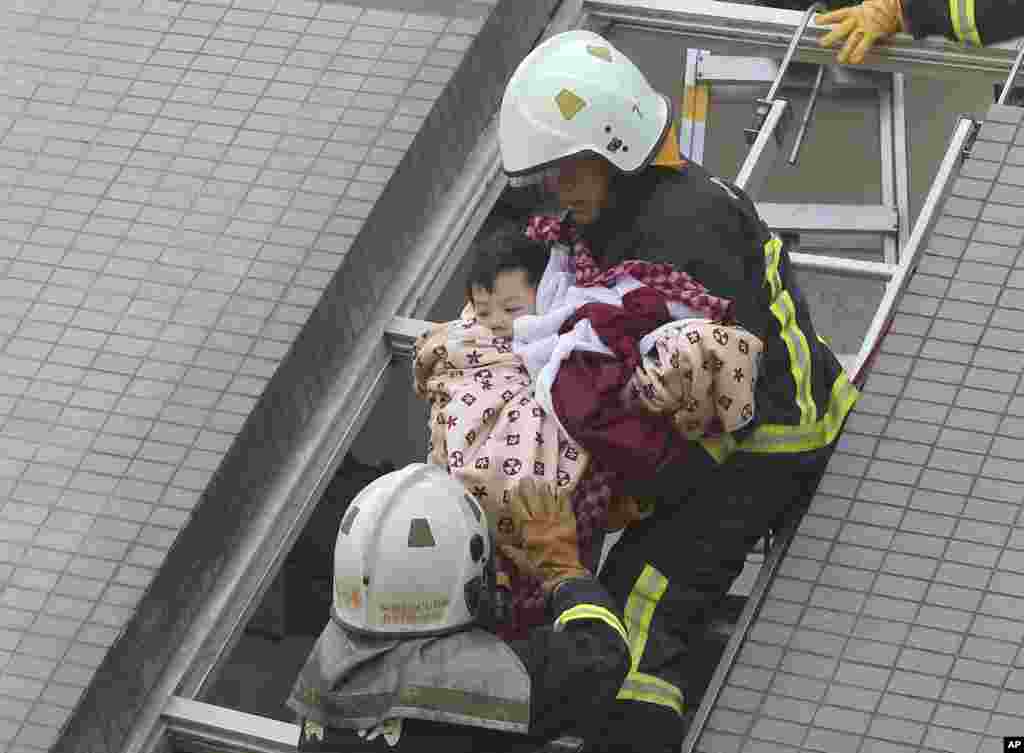 A child is rescued from a collapsed building. 