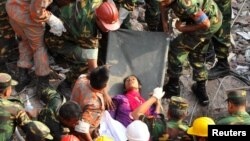 Tentara Bangladesh dan tim SAR saat menemukan seorang perempuan dalam keadaan selamat di antara reruntuhan gedung di Savar (10/5). Pencarian korban akan dihentikan Selasa 14/5.