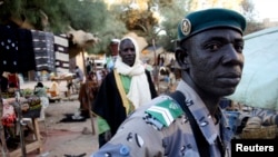 FILE: A Timbutku policeman patrols a central market where Al Qaeda was smuggling cocaine to Europe. The Africa Union’s Mission to Mali and the Sahel is consulting on increased cooperation among security forces of adjacent countries to curb the transit of drugs through the Sahel. 