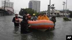 Lực lượng cứu hộ sử dụng thuyền cao su để di chuyển cư dân tại một khu vực bị ngập lụt ở thành phố Quezon, phía bắc Manila, ngày 7/8/2012