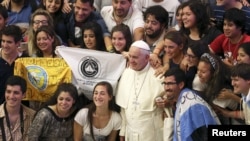 Pope Francis (C) poses for a picture with Argentinian youths during his Wednesday general audience in Paul VI hall at the Vatican, August 19, 2015. 