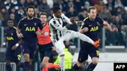 Douglas Costa, au centre, attaquant de la Juventus, face à Harry Kane, attaquant anglais de Tottenham, à droite, et à Mousa Dembele, milieu belge de Tottenham Hotspur, à gauche, au cours du match de seizièmes de finale de l'UEFA Champions League entre la