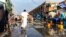 Un homme saute par-dessus une flaque d'eau dans le marché de la capitale inondé après une tempête le 2 avril 2019 à Nouakchott. (Photo by Carmen Abd Ali / AFP)