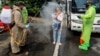 La police désinfectant des citoyens vénézuéliens de retour de Colombie, à titre préventif contre la propagation du coronavirus, au pont Simon Boliviar, Cucuta, 4 avril 2020. (Photo Schneyder Mendoza/AFP)