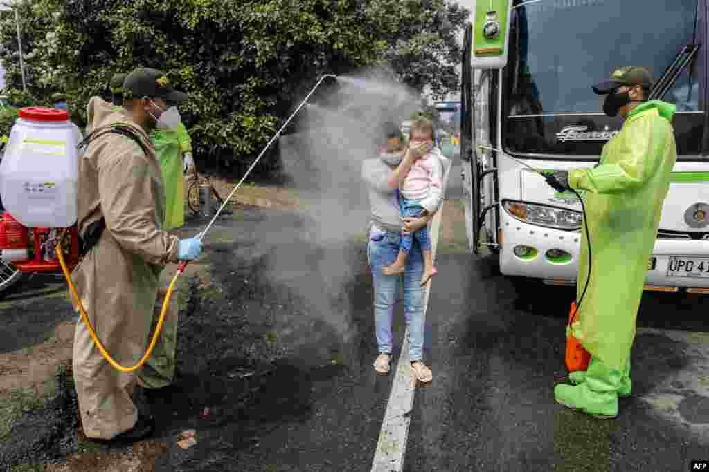 National Police members disinfect Venezuelan citizens returning to the country from Colombia, as a preventive measure against the spread of the coronavirus, at the Simon Boliviar International Bridge in Cucuta, Colombia-Venezuela border, April 4, 2020.