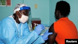 FILE - A health worker injects a woman with an Ebola vaccine during a trial in Monrovia, Feb. 2, 2015. 