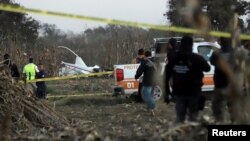 Police and rescue personnel stand at the scene where the helicopter transporting Martha Erika Alonso, governor of the state of Puebla, and his husband Senator Rafel Moreno Valle crashed, in Coronango, Puebla Mexico, Dec. 24, 2018.