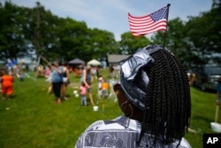 FILE - Malu Klo, an asylum-seeker from the Congo, attends a picnic for refugees at Fort Williams Park in Cape Elizabeth, Maine, July 4, 2019.