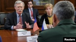 Russia's Defense Minister Sergei Shoigu, back to camera, meets with U.S. national security adviser John Bolton in Moscow, Oct. 23, 2018. 