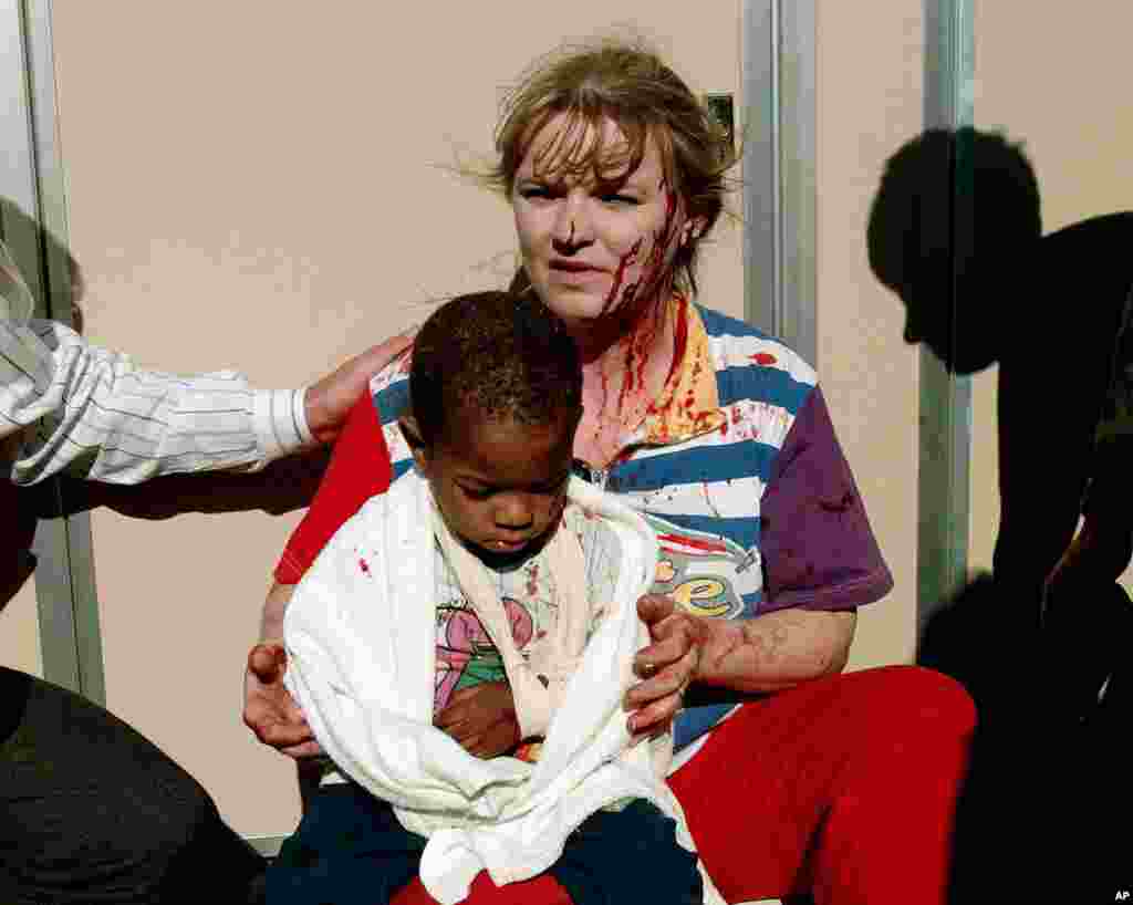 FILE - In this April 19, 1995 file photo, an injured woman holds a child following a blast that destroyed a large portion of the Alfred Murrah Federal Building in downtown Oklahoma City. 