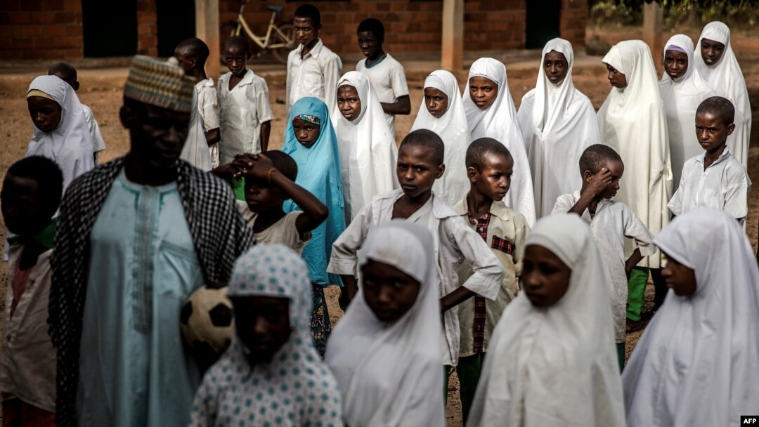 Un groupe d'étudiants peuls fait la queue sur les terrains de l'école avant le début des cours de la journée à l'école nomade Wuro Fulbe de la réserve de Kacha Grazing pour peuple Peul, État de Kaduna, au Nigeria, le 19 avril 2019.
