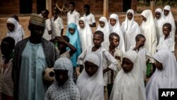 Un groupe d'étudiants peuls fait la queue sur les terrains de l'école avant le début des cours de la journée à l'école nomade Wuro Fulbe de la réserve de Kacha Grazing pour peuple Peul, État de Kaduna, au Nigeria, le 19 avril 2019.