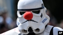 A cosplayer dressed as a Star Wars stormtrooper wears a red nose at a cosplayer meeting in Bottrop, Germany, Saturday, June 15, 2019. (AP Photo/Martin Meissner)