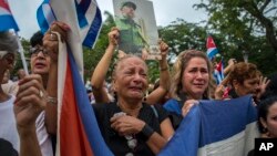 Women weep as the procession carrying the ashes of Cuba's leader Fidel Castro leaves the town of Santa Clara, Cuba, Dec. 1, 2016. 