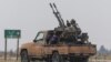 A rebel fighter sits on the back of a vehicle in Homs countryside