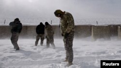 FILE - U.S. soldiers turn away as a U.S. Black Hawk helicopter takes off from a U.S. base in the Jaji district of the southeastern Paktia province, near the Afghan-Pakistan border.