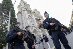 FILE - Police officers stand near Notre Dame church, where a knife attack took place, in Nice, France, Oct. 29, 2020.