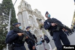Police officers stand near Notre Dame church, where a knife attack took place, in Nice, France, Oct. 29, 2020.