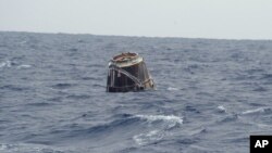 In this photo provided by SpaceX, the Dragon spacecraft floats on the surface of the Pacific Ocean about 500 miles off Mexico's Baja California after its mission to the International Space Station (ISS), May 31, 2012.