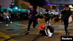 Manifestantes prodemocracia huyen de la policía que trata de dispersarlos en el primer aniversario del inicio de las protestas contra el gobierno el 9 de junio de 2020.