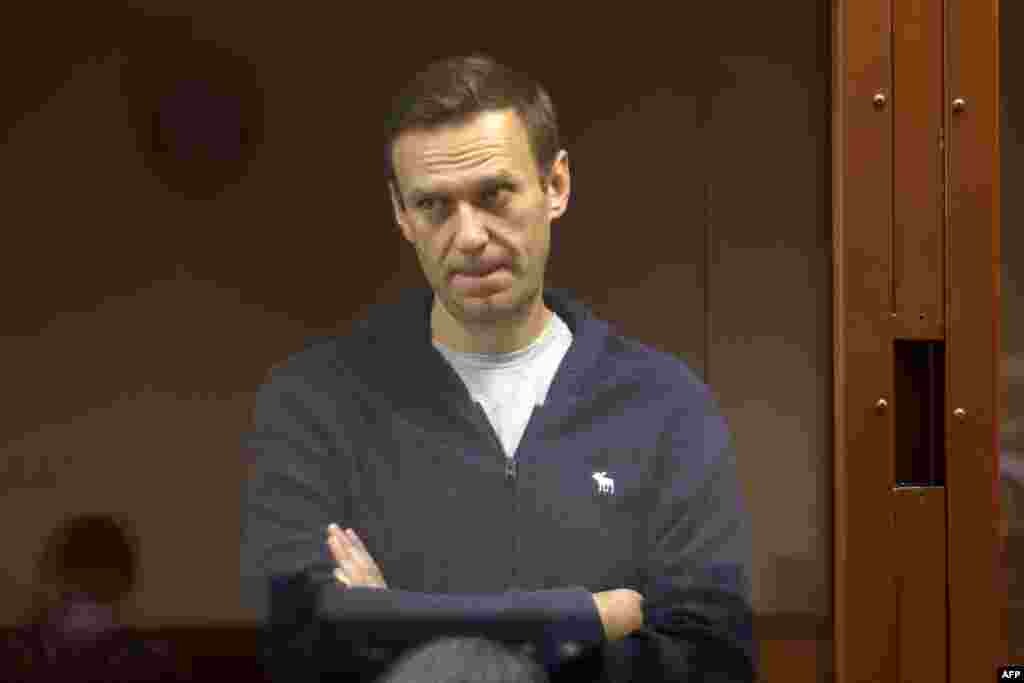 Russian opposition leader Alexei Navalny, charged with defaming a World War II veteran, stands inside a glass cell during a court hearing in Moscow, in this handout picture provided by the Babushkinsky district court.