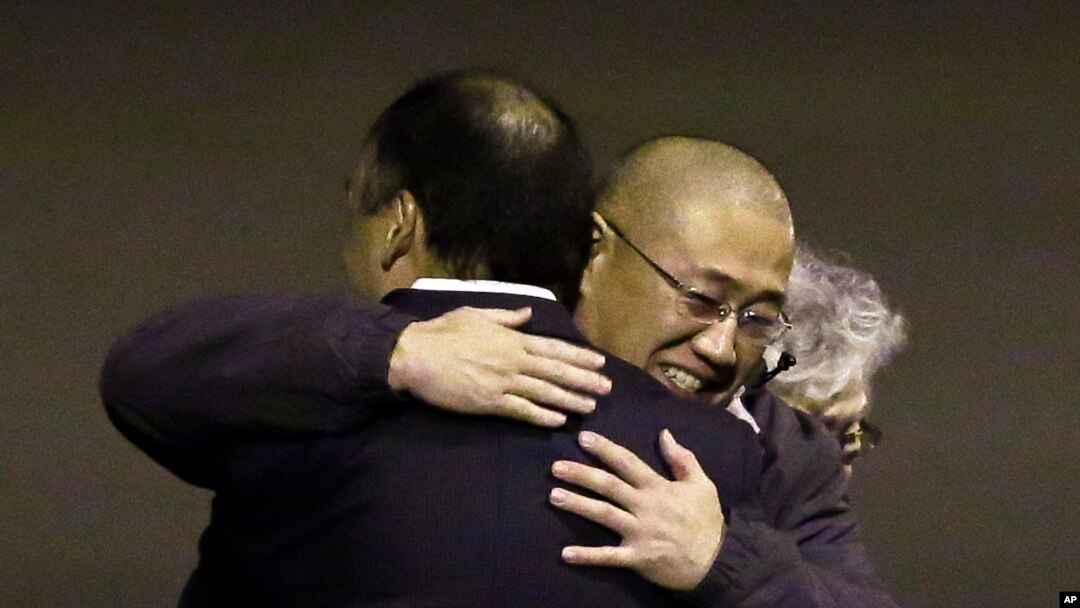 FILE - Kenneth Bae, center, who had been held in North Korea since 2012, is hugged after arriving at Joint Base Lewis-McChord, Washington, Nov. 8, 2014.
