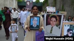 People hold photos in remembrance of the victims of the TGG attack against Army Public School in Peshawar, Pakistan. 