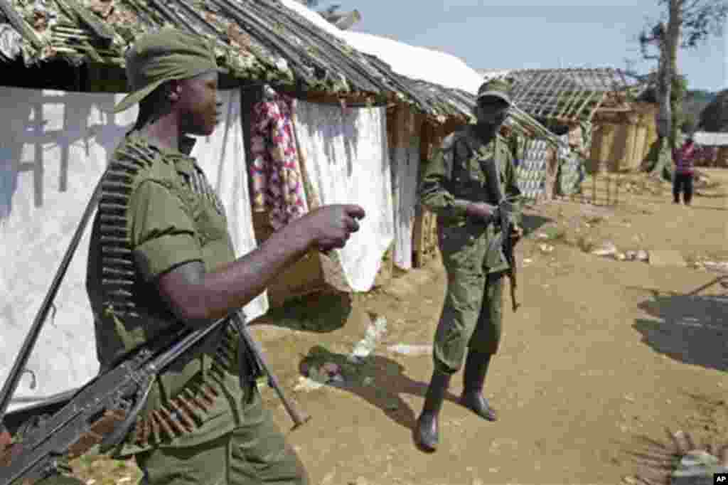 Congo troops provide security for villagers on the outskirts of Walikale, Congo, Friday, Sept. 17, 2010, where violence in this corner of Congo is reported to be spiraling out of control. Some hundreds of victims of a mass gang-rape has drawn internationa