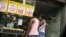 FILE - Women look at prices at a food market in Rio de Janeiro, Brazil, Jan. 21, 2016.