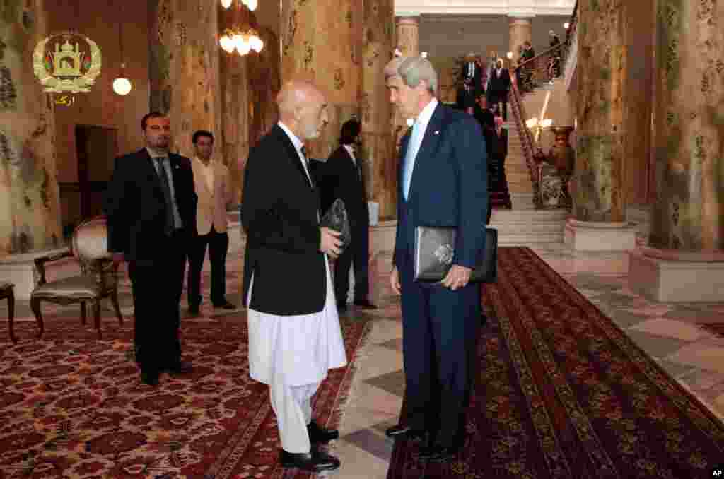 This image released by the Afghan presidential palace shows U.S. Secretary of State John Kerry talking with Afghanistan's President Hamid Karzai at the presidential palace in Kabul, July 11, 2014.